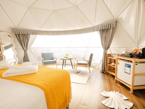 a bedroom with a bed and a table and chairs at L1 Lanta Resort in Ko Lanta