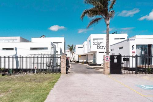 a palm tree in front of a white building at Eden Bay Mornington in Capel Sound
