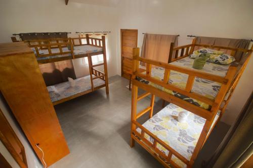 ein Zimmer mit drei Etagenbetten in einem Zimmer in der Unterkunft Verde Bungalows Siargao in General Luna