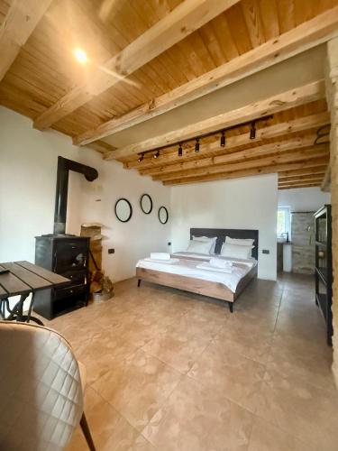a large bedroom with a bed and a wooden ceiling at Онгъл Харман in Kŭrpachevo
