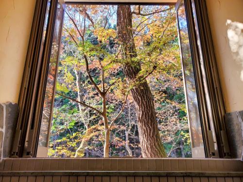 a window with a view of a tree at Yama no Ie in Nikko
