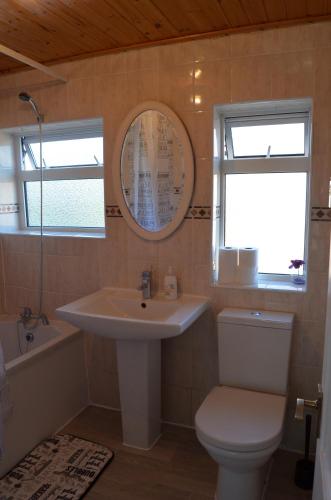 a bathroom with a sink and a toilet and a mirror at Old Trafford Guest House in Manchester