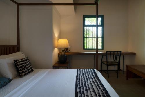 NikawatawanaにあるMaligathennaのベッドと机と窓のある寝室