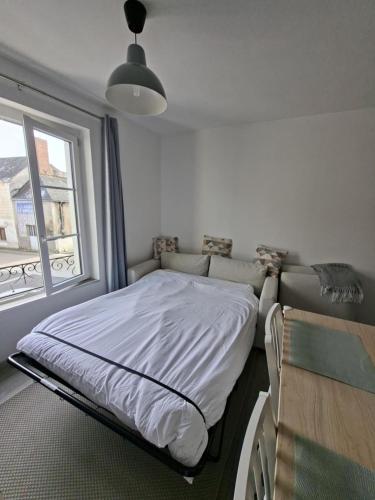 a bed in a room with a window at Chamaillard 1, calme, draps fournis in L'Ile-Bouchard