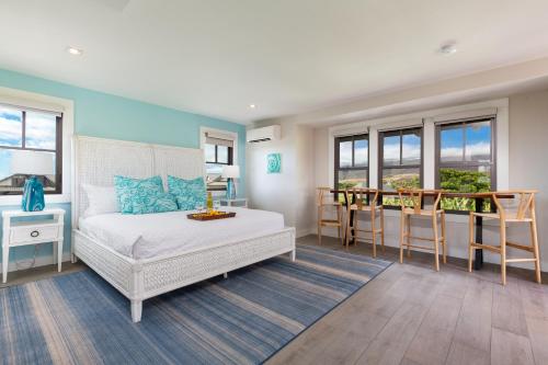 ワイメアにあるBLUE SERENITY Luxurious home in private community with Heated Private Pool Spa Detached Ohana Suiteのベッドとテーブルと椅子のある寝室