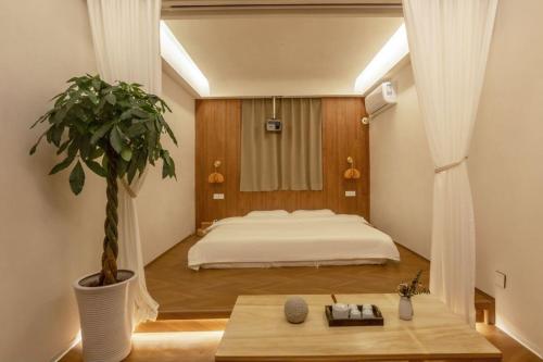 una camera da letto con un letto e una pianta in vaso di Tangyin Courtyard Hotel a Xi'an