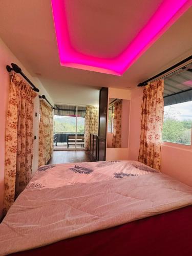 a bedroom with a bed with a pink ceiling at Breeze Heven Cabana in Matale