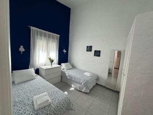 a blue and white bedroom with two beds and a refrigerator at Mar y Sol in Maspalomas