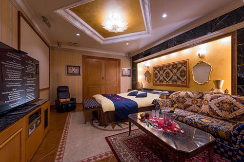 a hotel room with a bed and a couch at HOTEL C-L'esapce in Honjo