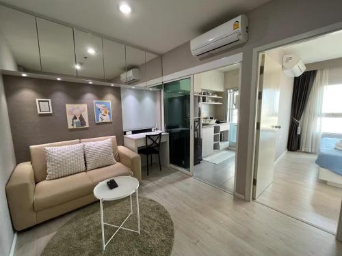 a living room with a couch and a table at 1BR Walk 1min to BTS 3min Mall Tapra WiFi 500MB in Bangkok