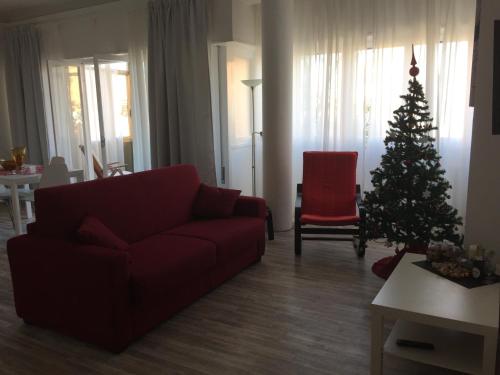 a living room with a christmas tree and a red couch at St Peter Lodge in Rome