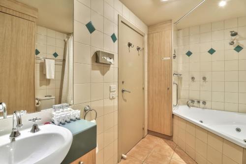 曼斯菲尔德阿斯堡度假酒店的带水槽、浴缸和淋浴的浴室