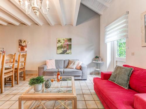 UbachsbergHoliday Homes in Ubachsberg with a Picturesque Garden的客厅里有一张红色的沙发和一张桌子