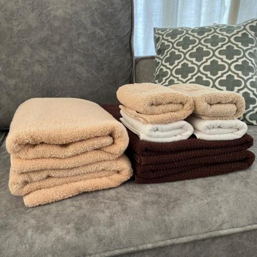 a pile of towels sitting on top of a couch at お宿 垢田の杜　桂月 in Hatabu