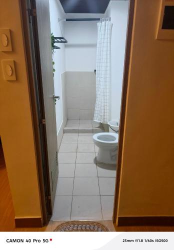 a small bathroom with a toilet and a shower at K&C Suite in Trece Martires