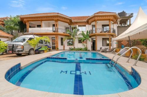una grande piscina davanti a una casa di Entebbe Hotel a Entebbe