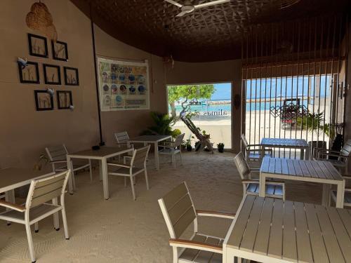 um restaurante com mesas e cadeiras e vista para a praia em Alimas Holiday Retreat Maldives em Felidhoo