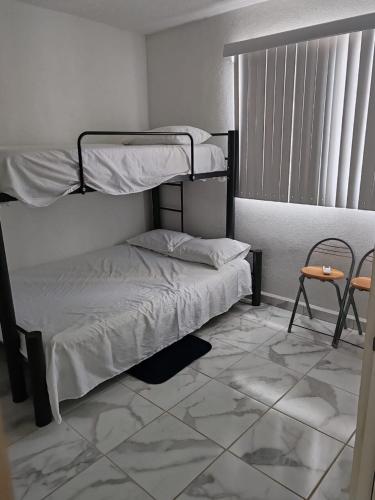 a bedroom with two bunk beds and a tiled floor at Departamento Premium en Acapulco in La Sabana