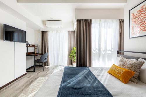 a bedroom with a bed with a television and a desk at Dash Living Ryogoku in Tokyo