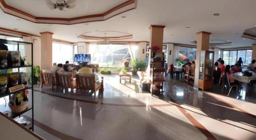 a lobby of a restaurant with people sitting at tables at Ritzy House Hotel in Na Dhung