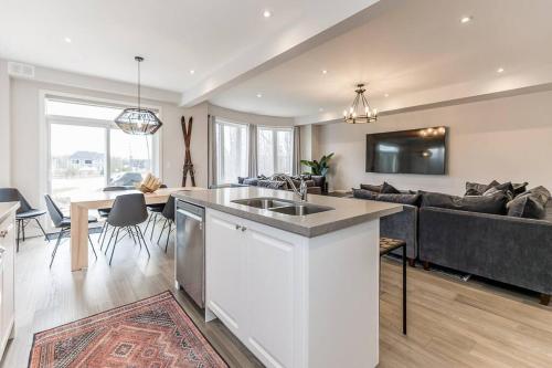 eine Küche und ein Wohnzimmer mit einem Sofa in der Unterkunft Modern Luxury Townhome Walk to Blue Shuttle in Blue Mountains