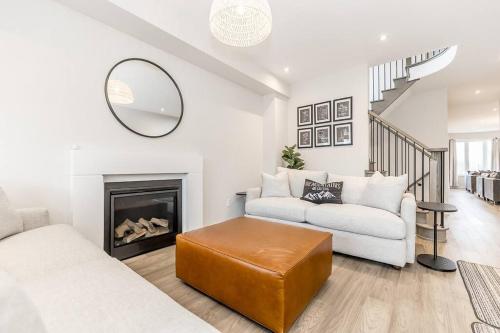 ein Wohnzimmer mit Sofa und Kamin in der Unterkunft Modern Luxury Townhome Walk to Blue Shuttle in Blue Mountains