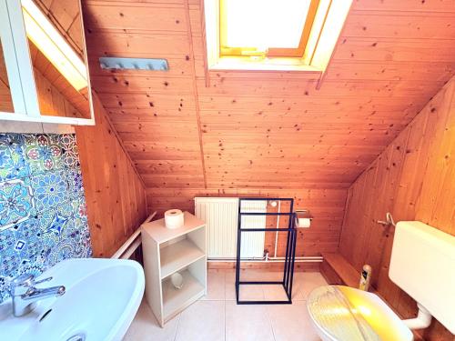 a bathroom with a blue sink in a wooden attic at Ferienhaus Nele - ein strandnahes, einfaches Haus in Breege