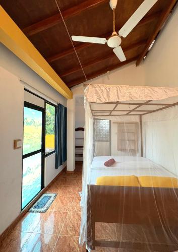 a bedroom with a bed and a ceiling fan at Weligama Imal Guest House in Weligama