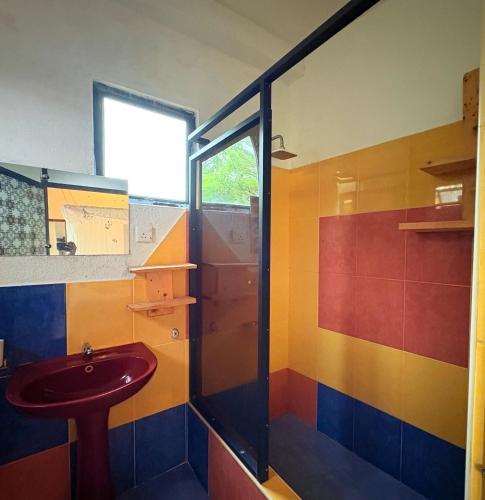 a colorful bathroom with a sink and a shower at Weligama Imal Guest House in Weligama