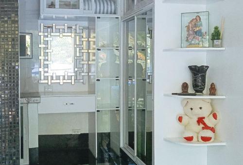ein Teddybär, der in einem Zimmer auf einem Regal sitzt in der Unterkunft KrizLion Hotel in Hinatuan