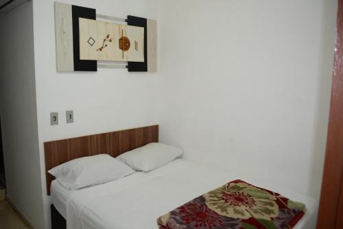 a bedroom with a bed and a clock on the wall at Lize Hotel in Campinas