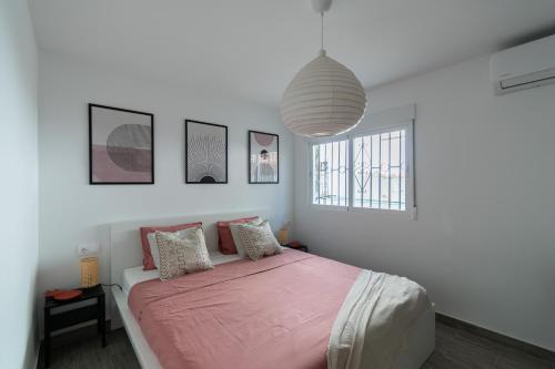 a bedroom with a bed with a pink blanket at Satu Granada Modern Apartment in the Albaicín in Granada