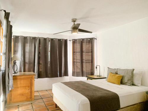 a bedroom with a bed and a window with curtains at Casa Hidalgo Hideaway in Chapala