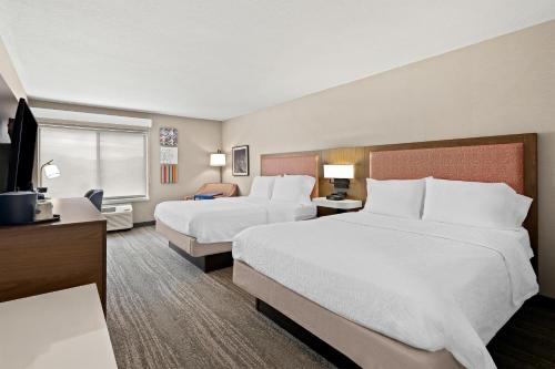 a hotel room with two beds and a television at Hampton Inn Provo in Provo