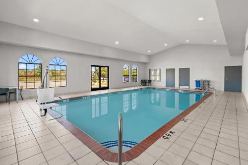 a large swimming pool with blue water in a building at Spark By Hilton North Little Rock in North Little Rock