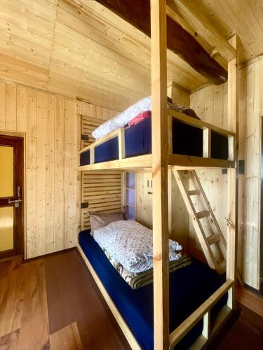 a bedroom with bunk beds in a wooden cabin at SpitiDiaries Homestay in Kaza