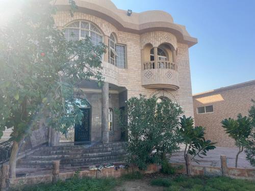 doge villa 4 في دبي: منزل كبير مبني من الطوب مع شرفة وشرفة أمامية