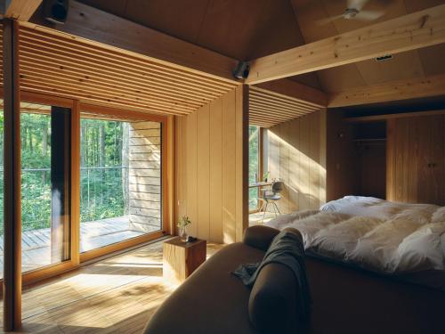 a bedroom with a bed and a large window at SANU 2nd Home 白馬 1st in Hakuba