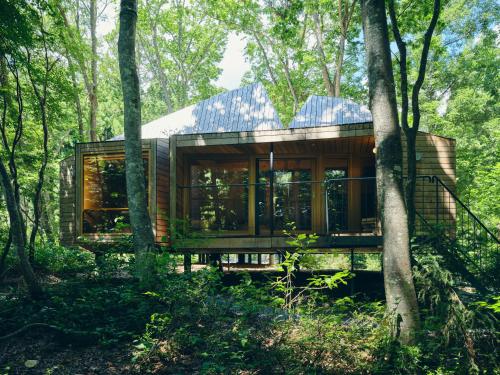 a house in the woods with a lot of windows at SANU 2nd Home 白馬 1st in Hakuba