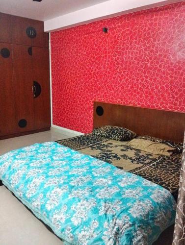 マンガロールにあるMohtisham Oasis Apartmentの赤い壁のベッドのある寝室