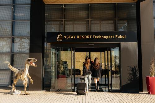 a dinosaur statue in front of aissery research technology fund building at 9stayリゾートテクノポート福井 in Sakai