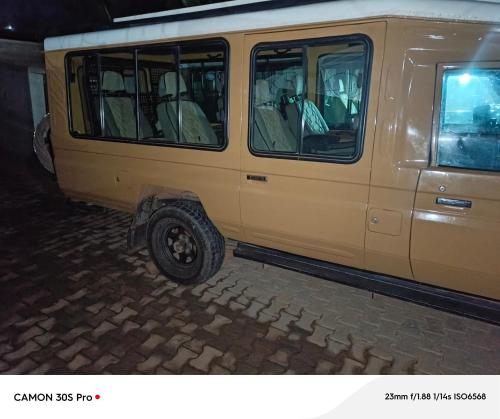 een gele bestelwagen geparkeerd op een bakstenen straat bij Kalz suites in Mbarara