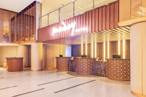 a lobby of a hotel with a row of bar at Sunday Hotel Arshika Sunset Road in Kuta