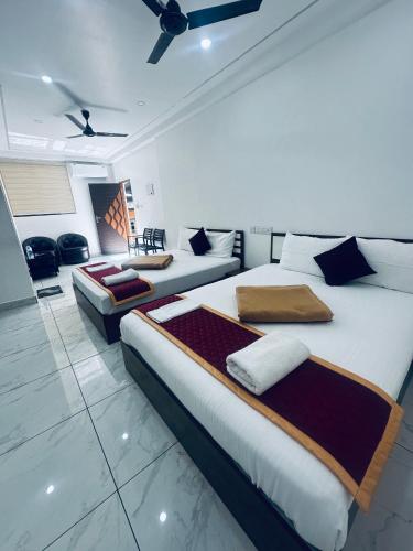 a bedroom with two beds and a living room at RKM Pearl in Cochin