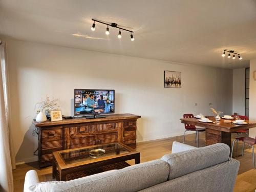 ルーヴァン・ラ・ヌーヴにあるCosy Homeのソファ、テレビ、テーブルのあるリビングルーム