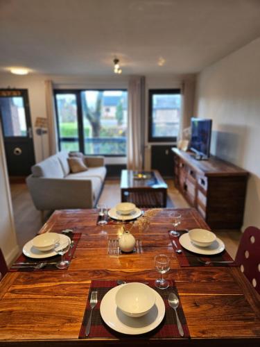 ルーヴァン・ラ・ヌーヴにあるCosy Homeのリビングルーム(木製テーブル、皿付)