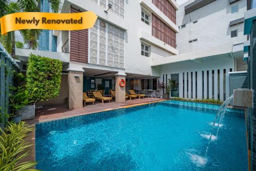 a swimming pool in front of a building at Ratana Hotel Rassada, PHUKET TOWN- SHA Extra Plus in Phuket