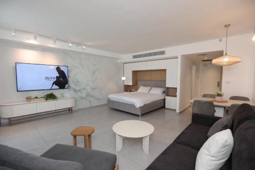 a living room with a bed and a tv at Sweet Sea Side Eilat - סוויט סי סייד, אילת in Eilat