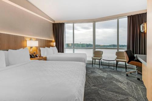 a hotel room with a bed and a large window at Clarion Lakeside Inn & Conference Centre in Kenora