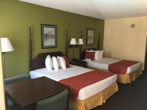 a hotel room with two beds and a table at Americas Best Value Inn - Malvern in Malvern